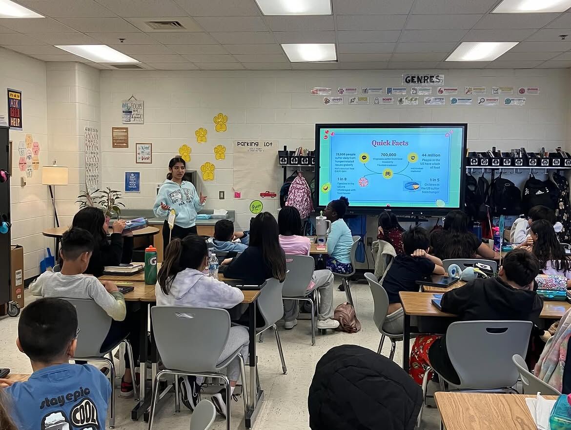 An ambassador leads a lesson in front of a full elementary classroom